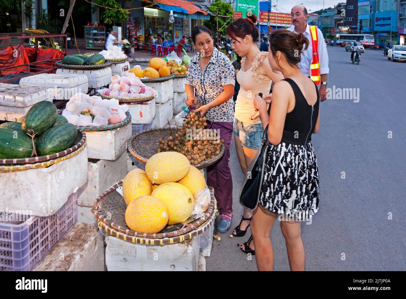 Clients au marché de rue du soir, Hai Phong, Vietnam Banque D'Images