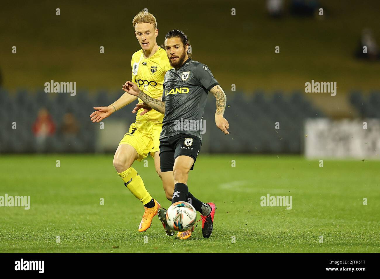 31st août 2022 ; Campbelltown Sports Stadium, Leumeah, Nouvelle-Galles du Sud, Australie ; Australie Coupe De la Ligue, quart de finale, MacArthur FC contre Wellington Phoenix: Daniel de Silva de MacArthur FC protège le ballon de Nicholas Pennington de Wellington Phoenix Banque D'Images