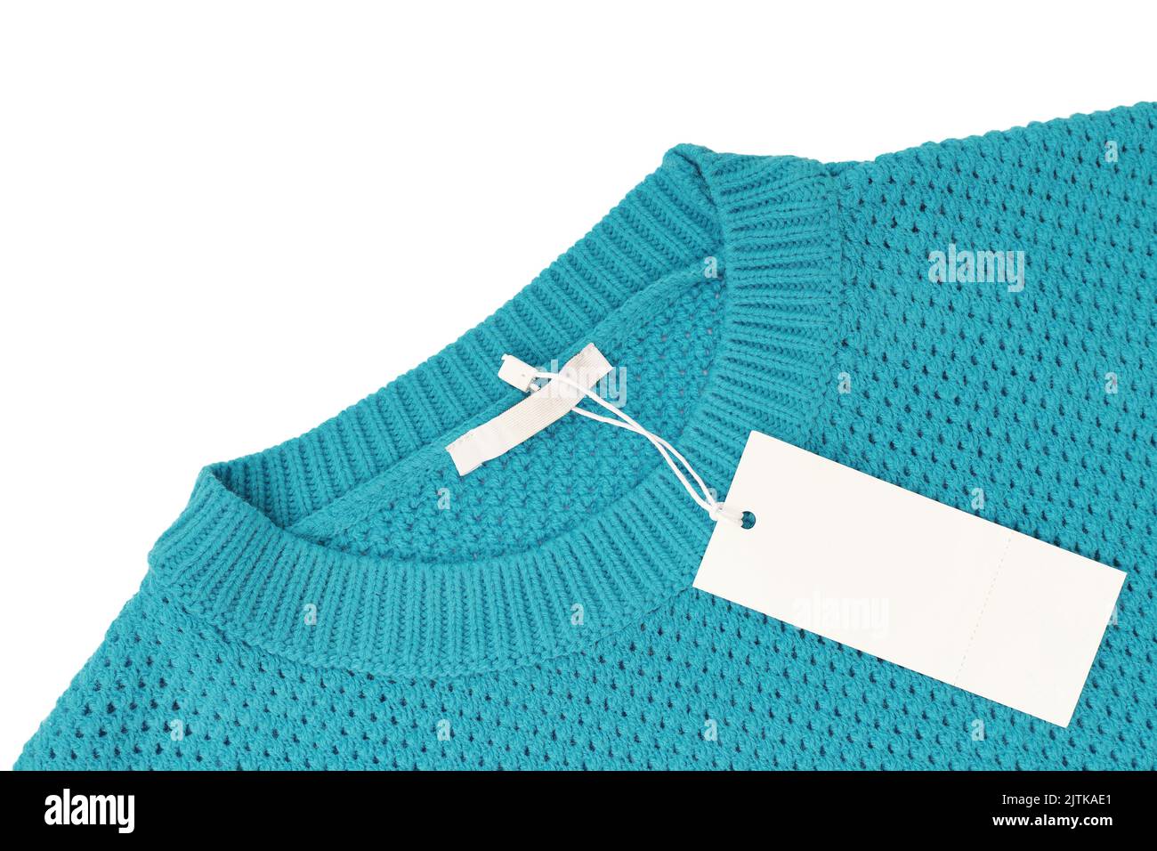 Blanc vierge rectangulaire étiquette de vêtements, modèle de maquette d'étiquette sur chandail tricoté turquoise isolé sur fond blanc . Étiquette de prix avec copie de la flèche Banque D'Images