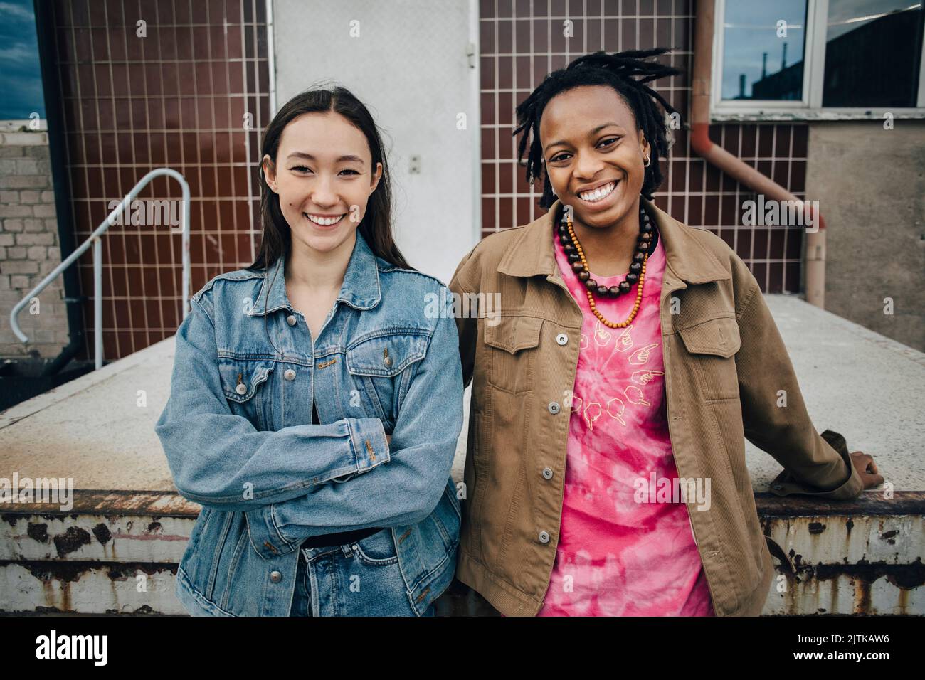 Portrait de jeunes femmes multiraciales souriantes debout devant le bâtiment Banque D'Images