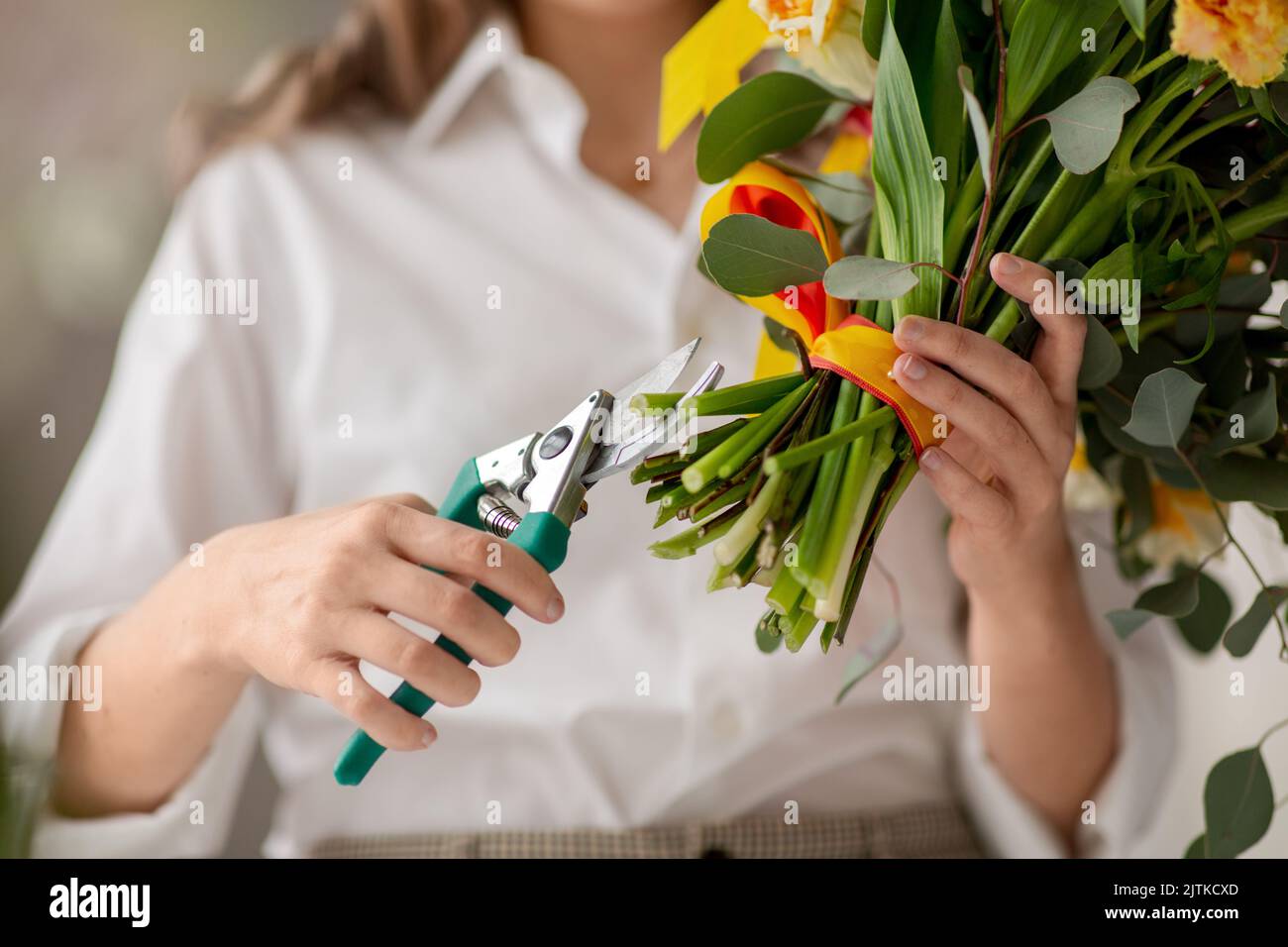 gros plan de femme organisant des fleurs au studio Banque D'Images