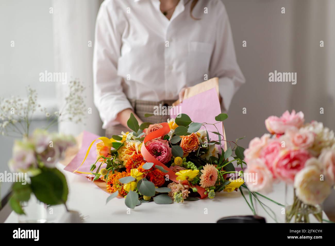 femme emballant des fleurs pour faire du papier au studio Banque D'Images