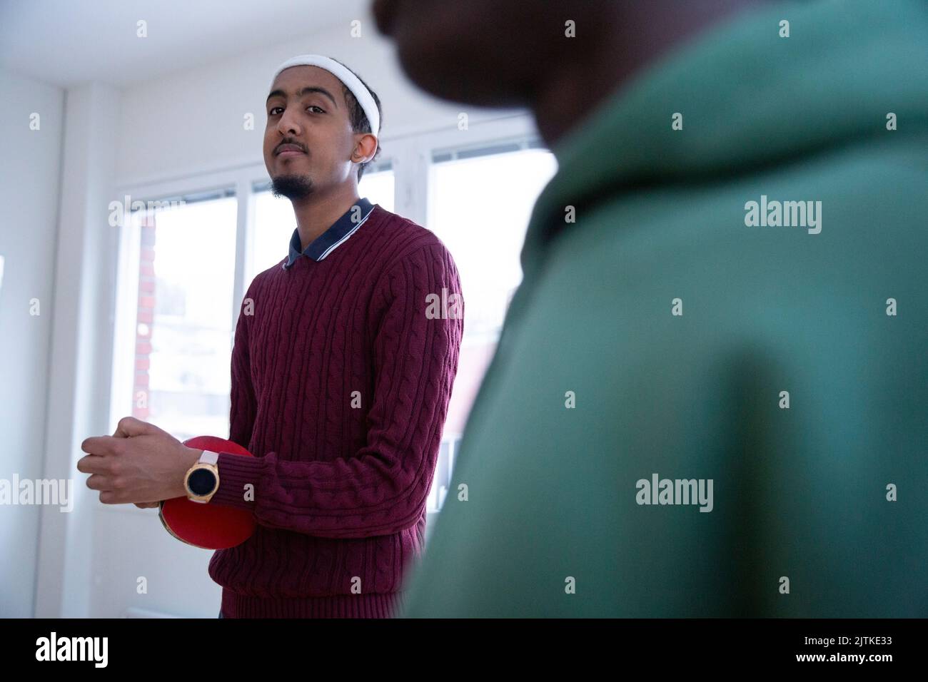 Portrait d'un jeune homme avec raquette de tennis de table pendant la séance d'entraînement dans la salle de jeux Banque D'Images