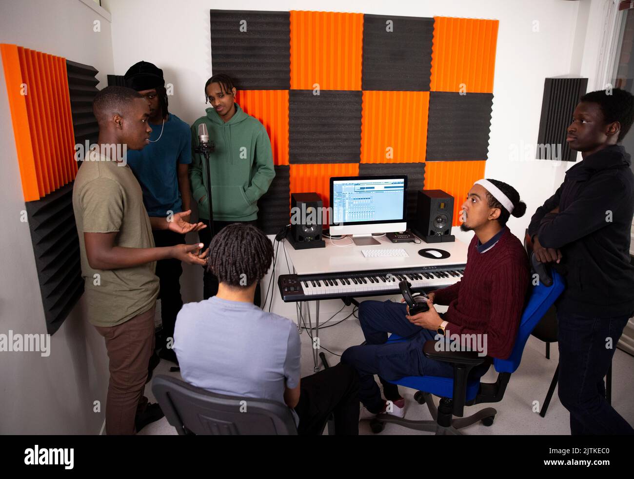 Une équipe d'artistes de musique discutant en studio d'enregistrement Banque D'Images