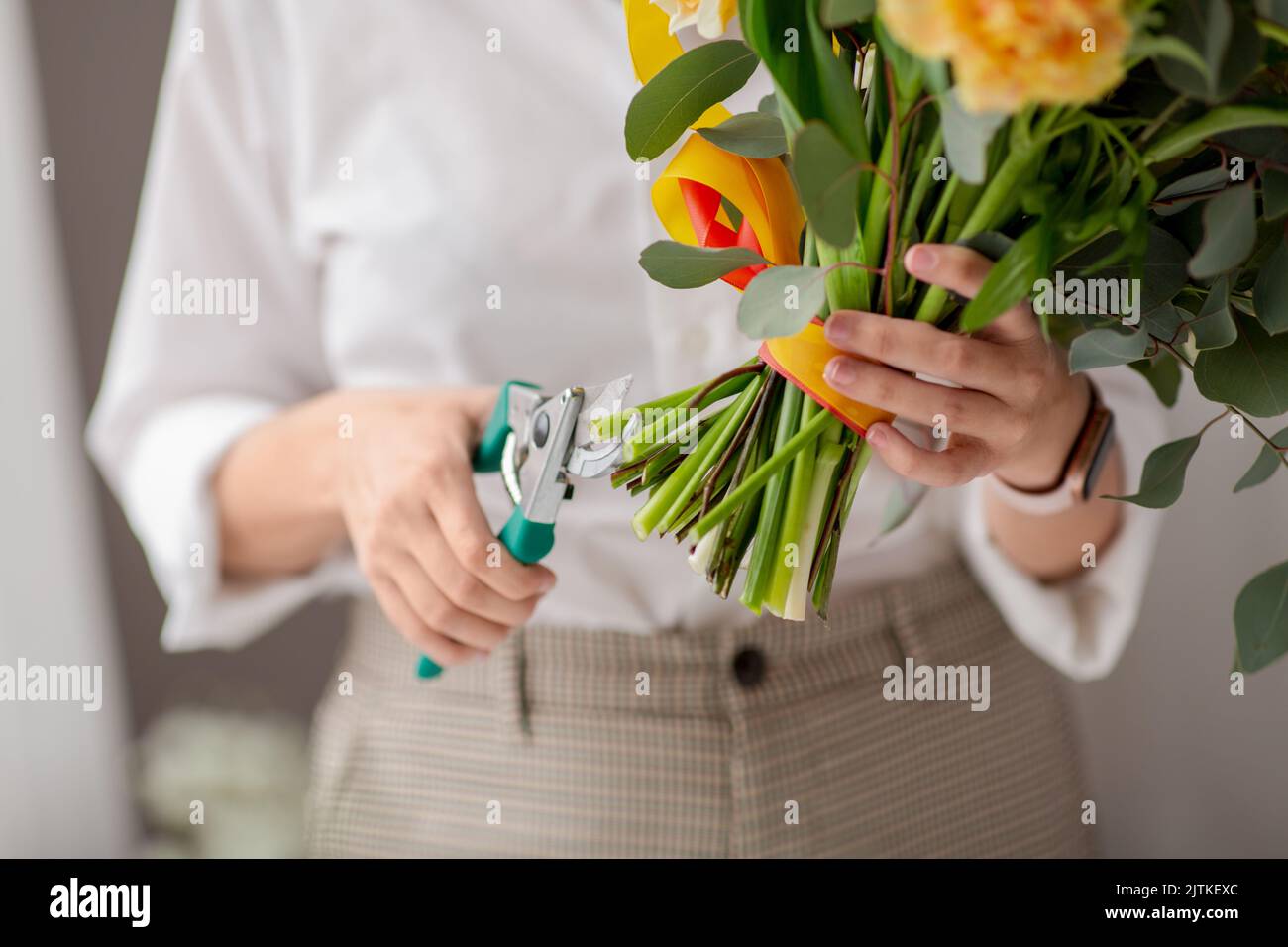 gros plan de femme organisant des fleurs au studio Banque D'Images