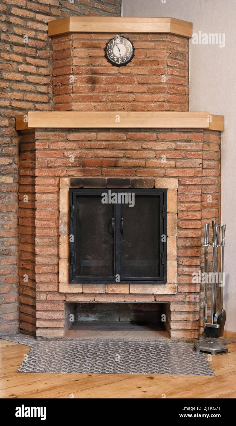 Vue de face d'une vieille cheminée en briques avec portes noires isolées sur blanc Banque D'Images