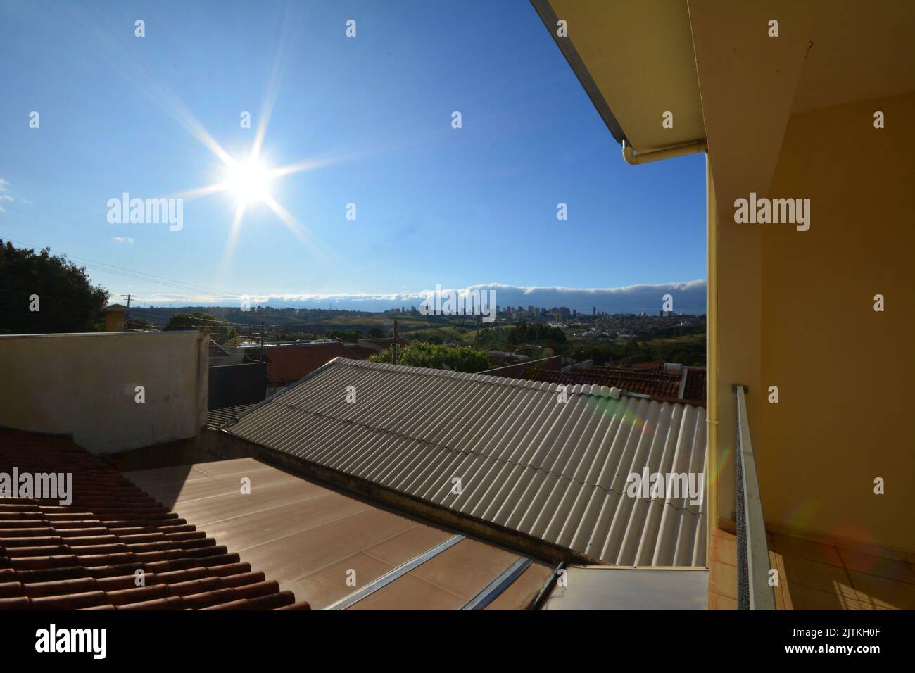 Balcon. Vue panoramique du centre-ville avec soleil, nuages de front froid et garde-corps en premier plan, ciel bleu, grand angle, campagne de São Paulo, Braz Banque D'Images