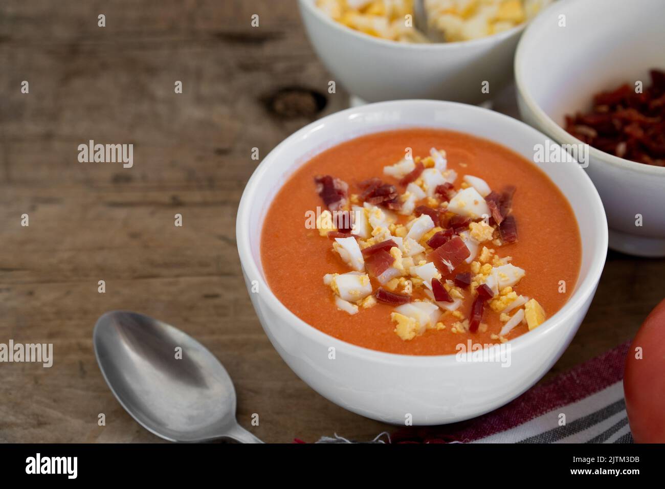 Soupe froide traditionnelle espagnole salmorejo à base de tomates, de pain, d'ail et d'huile d'olive, servie avec des œufs durs et du jambon serrano Banque D'Images