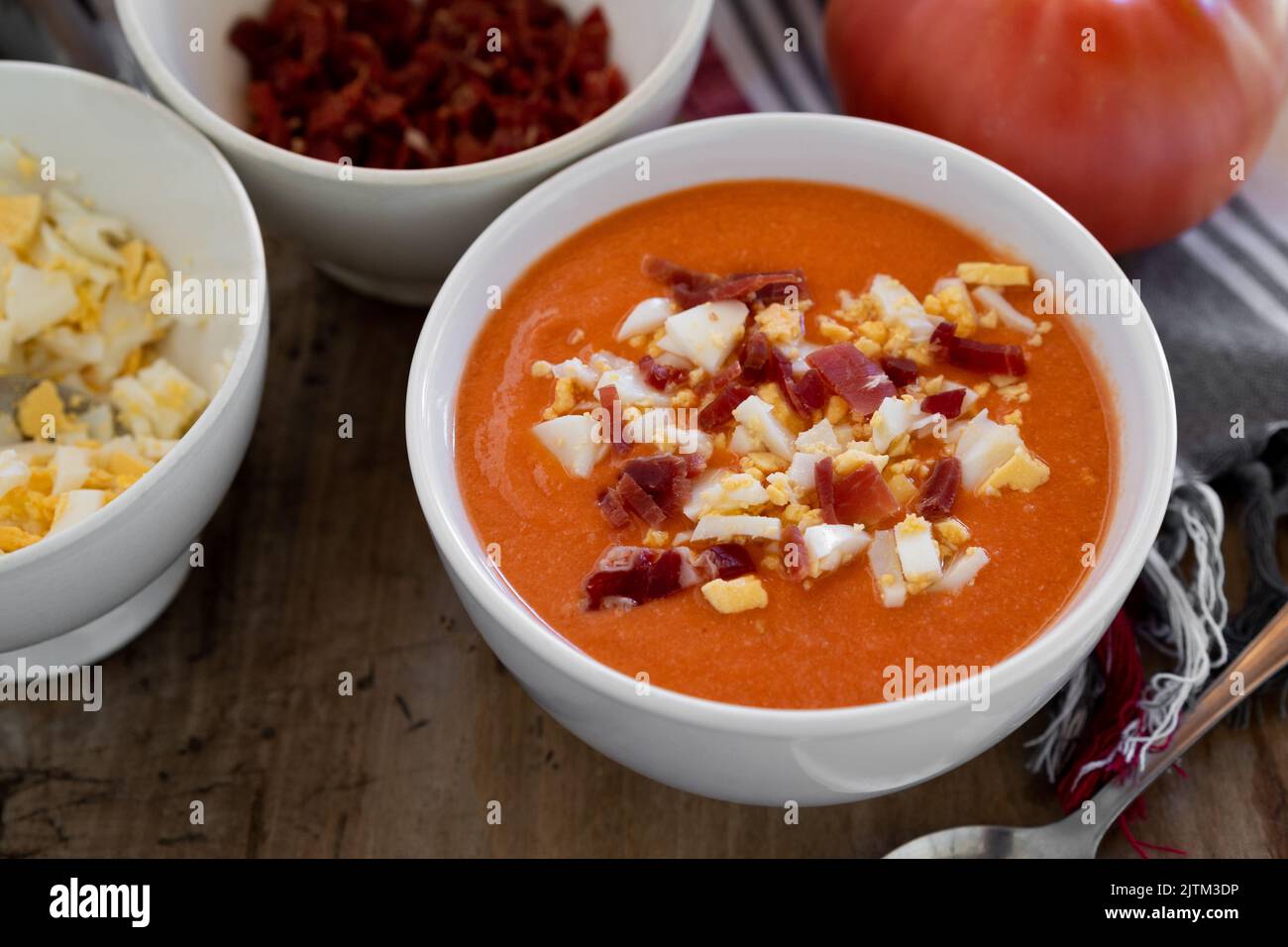 Soupe froide traditionnelle espagnole salmorejo à base de tomates, de pain, d'ail et d'huile d'olive, servie avec des œufs durs et du jambon serrano Banque D'Images