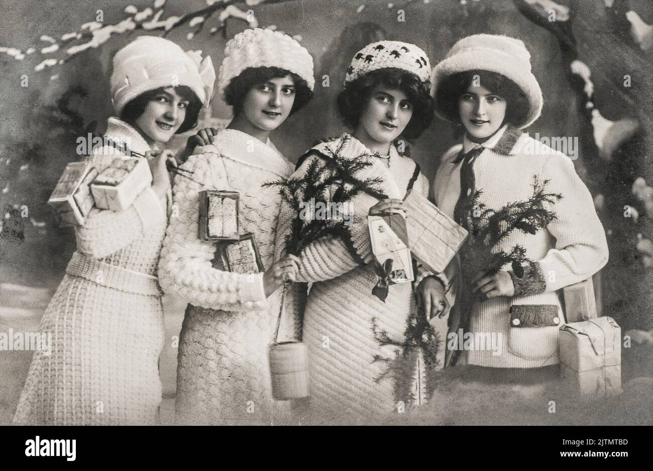 Jeunes femmes avec cadeaux et arbre de noël. Image vintage avec grain et flou de film d'origine Banque D'Images
