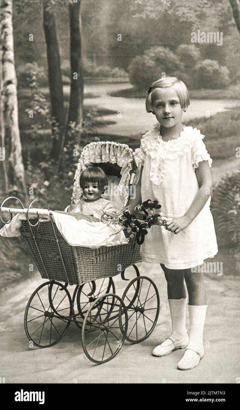 Photo ancienne de petite fille avec jouet de poupée. Image vintage Berlin, Allemagne Banque D'Images