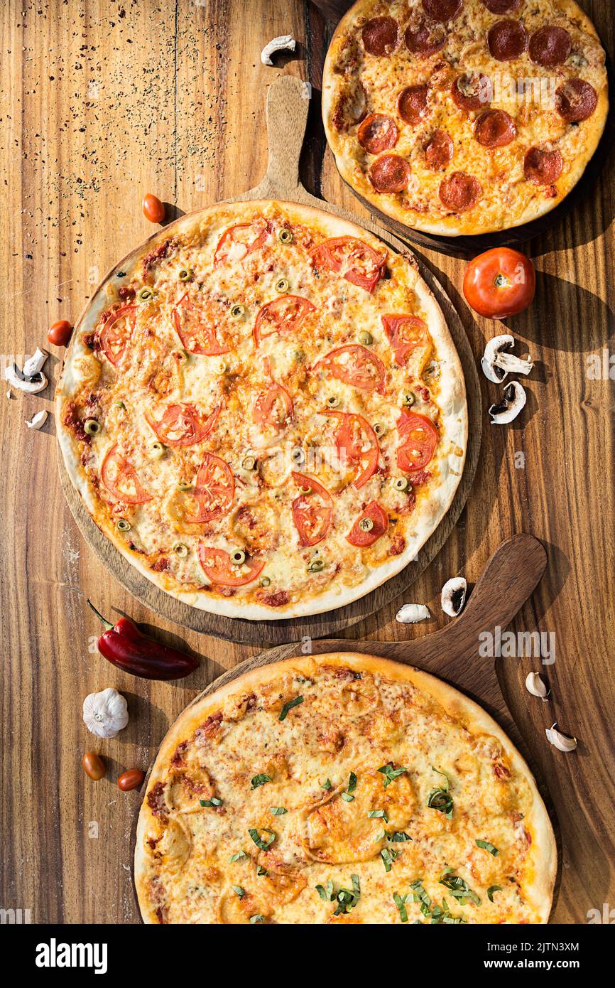 Trois pizzas aux saveurs différentes. Pepperoni, fromage, pomme de terre, oignon, tomate. Pizza italienne de qualité. Banque D'Images