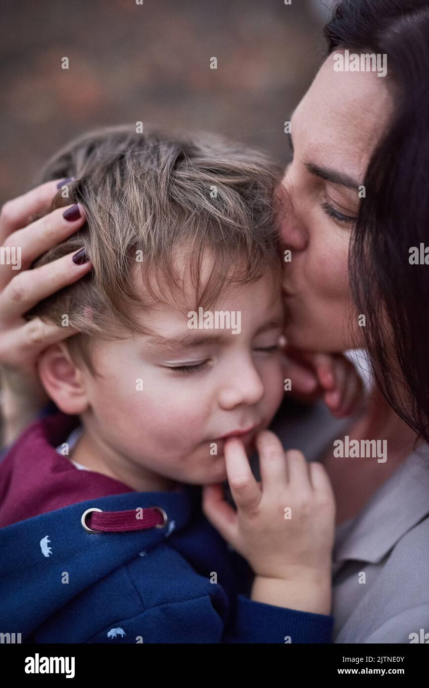 Tendre amour maternel. Une mère embrassant son petit fils. Banque D'Images