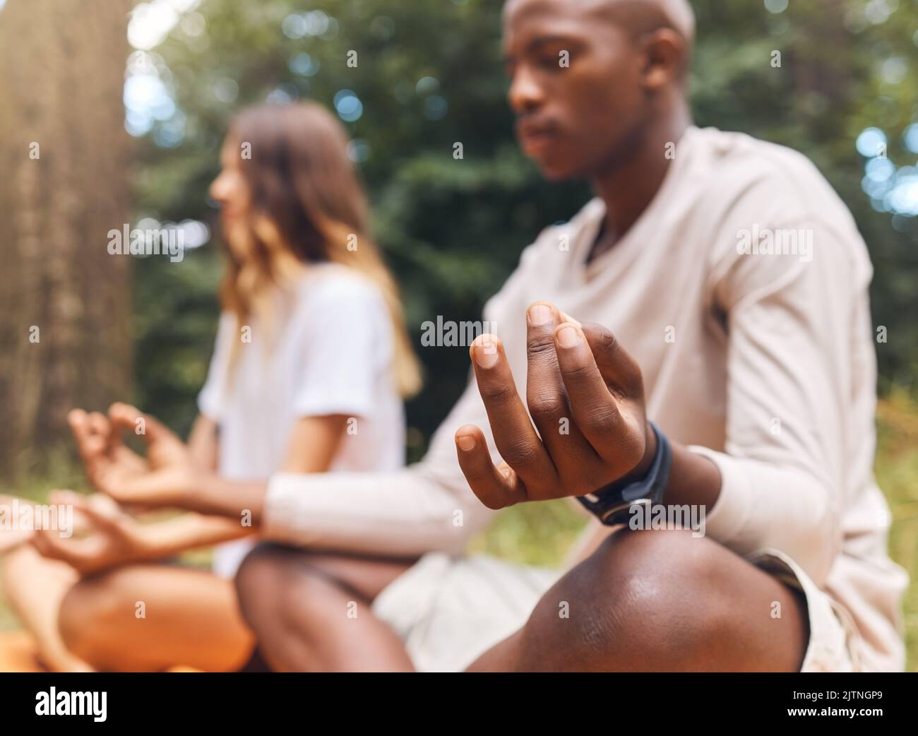 La méditation de la nature, le yoga et le zen de couple dans une forêt écologique ou détendez la santé de l'esprit de formation pour l'énergie bien-être ou la paix. Homme ou femme interracial dans Banque D'Images