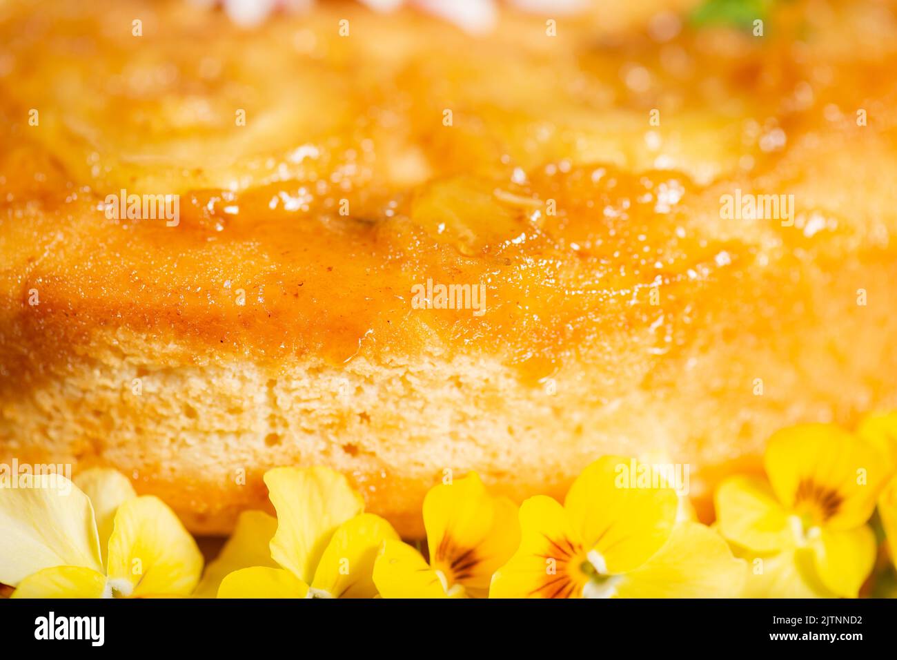 Gâteau à l'ananas maison à l'envers avec menthe et fleurs comestibles décoratives. Banque D'Images