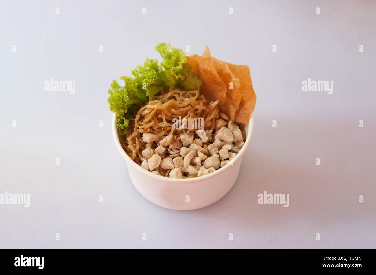 Mie Ayam ou nouilles de poulet sur fond blanc. Nouilles de blé jaune avec garniture de viande de poulet, servies avec des boulettes frites, Banque D'Images