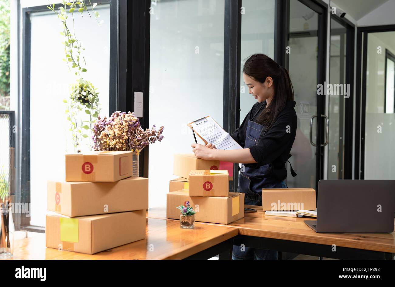 Jeune propriétaire d'entreprise écrivant l'adresse sur la boîte en carton. Petite entreprise entrepreneur PME. Expédition d'achats en ligne, Banque D'Images