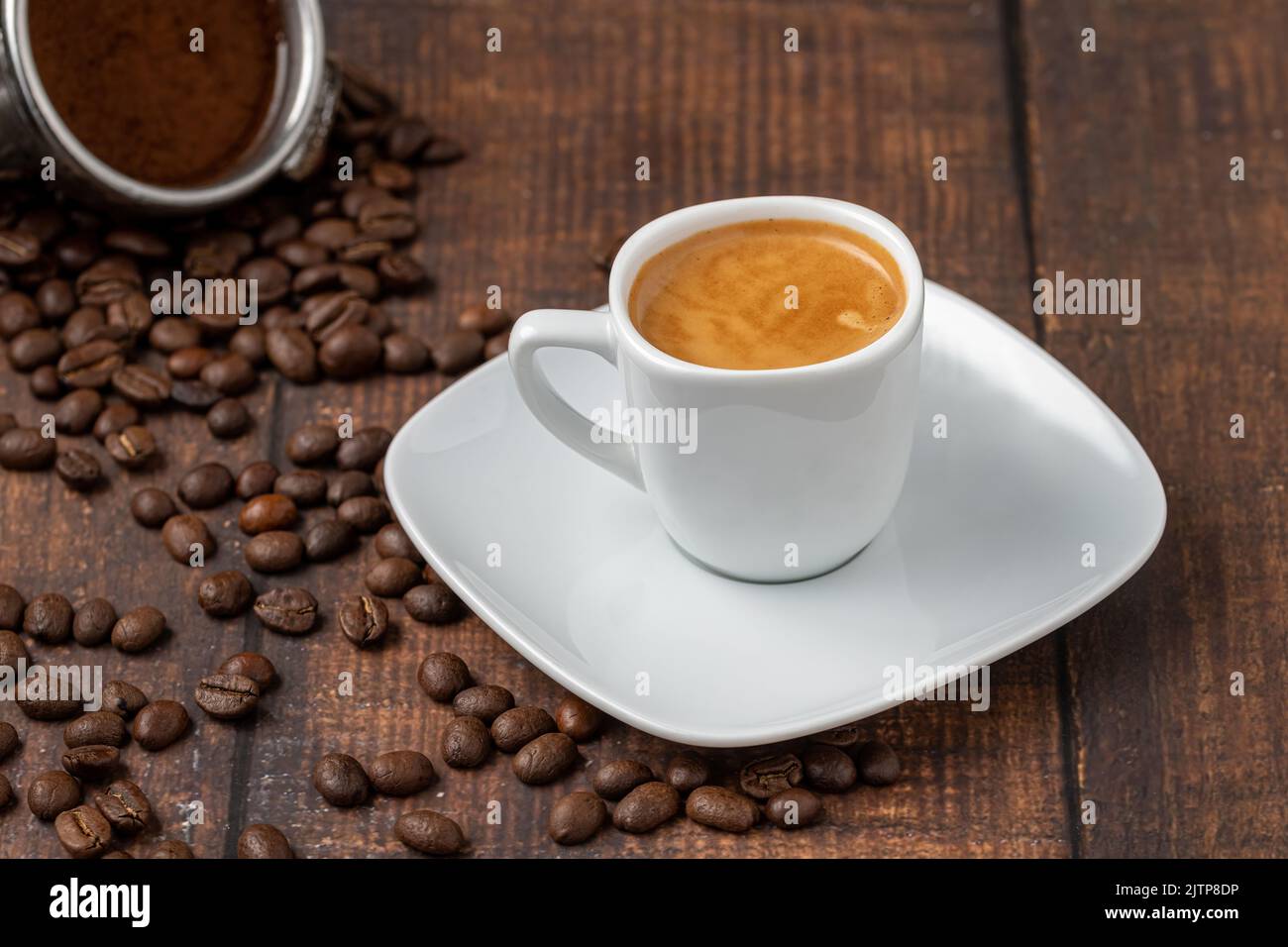 Café expresso frais et grains de café sur une table en bois Banque D'Images