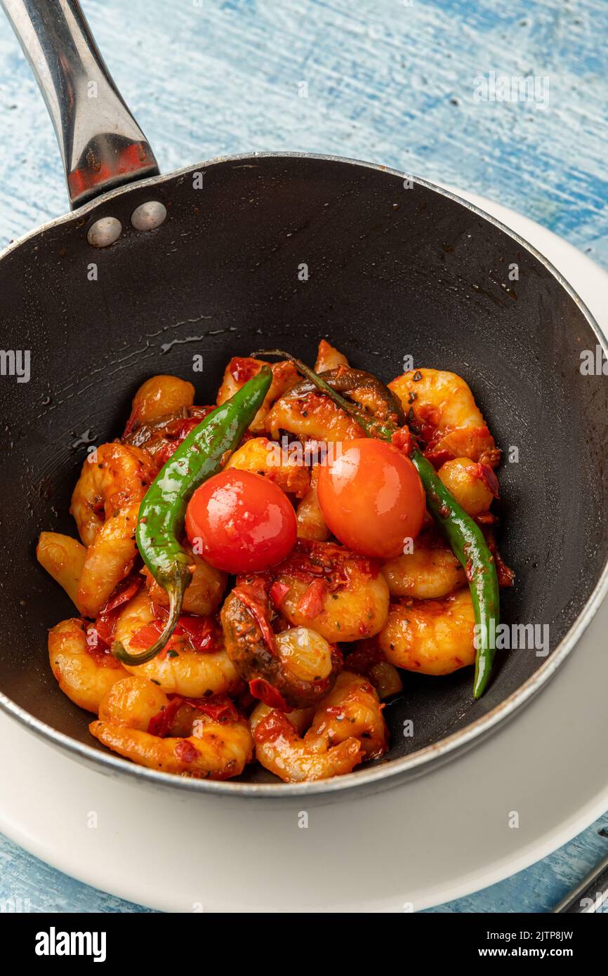 Cocotte de crevettes avec tomates, ail et poivrons dans un wok noir Banque D'Images