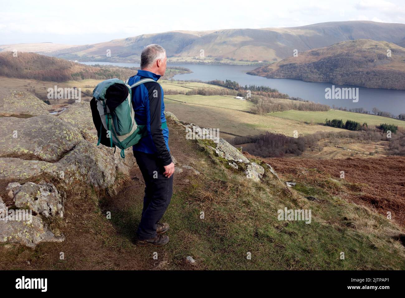 Homme âgé solitaire sur la piste du Yew Crag en direction du lac Ullswater dans le parc national du Lake District, Cumbria, Angleterre, Royaume-Uni Banque D'Images