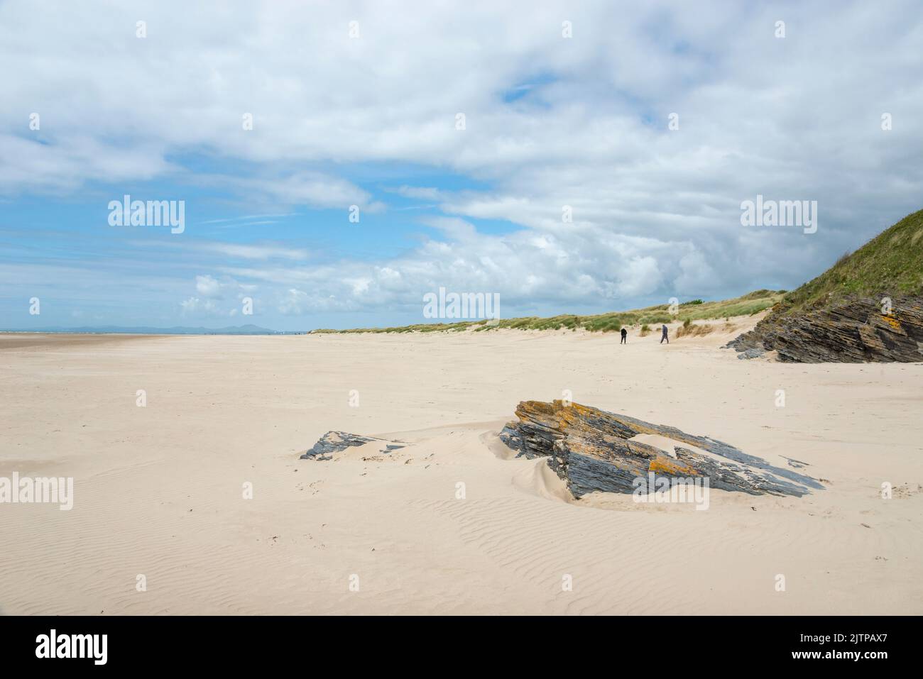 Marcheurs sur la plage de Morfa Bychan près de Porthmadog sur la côte du nord du pays de Galles. Banque D'Images