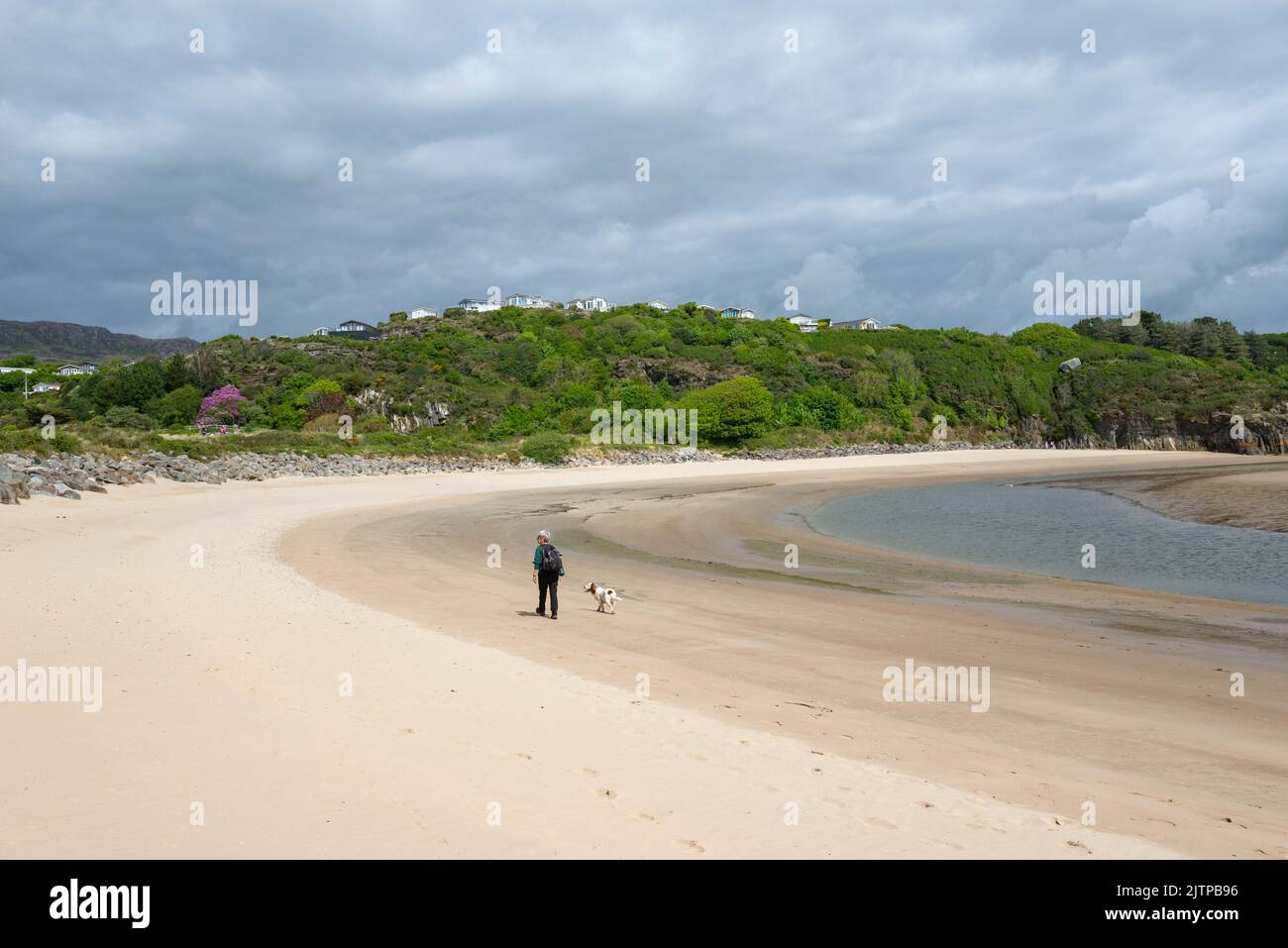 Femme et son chien sur la plage entre Borth-y-Gest et Ynys Cyngar près de Morfa Bychan, au nord du pays de Galles. Banque D'Images
