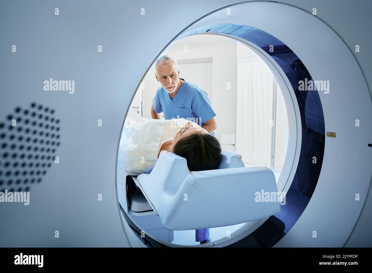 Un technologue en acquisition CT qui domine le patient dans le scanner de tomodensitométrie pendant la préparation de la procédure. Femme entrant dans le scanner CT Banque D'Images