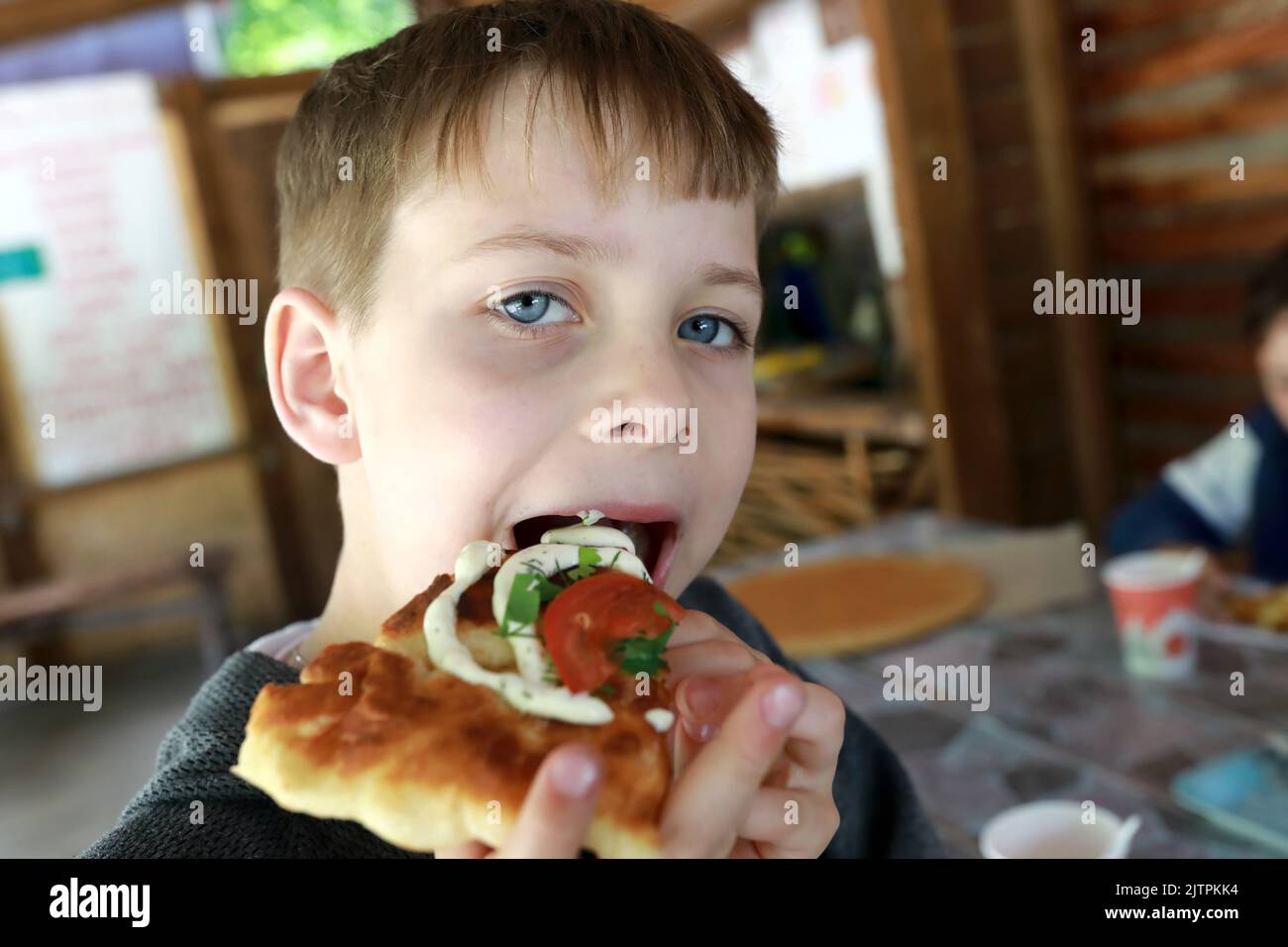 Un enfant mangeant du pain de pita adyghe dans le restaurant Banque D'Images