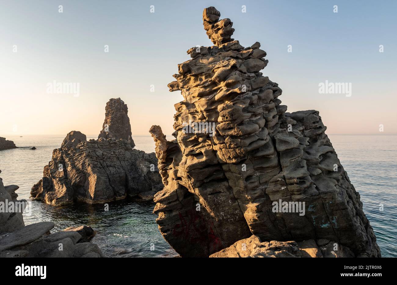 Le Faragghiuneddi, un affleurement volcanique surréaliste de lave dans la ville d'ACI Trezza, Catane, Sicile, Italie, près de l'Isole dei Ciclopi (les Faraglioni) Banque D'Images