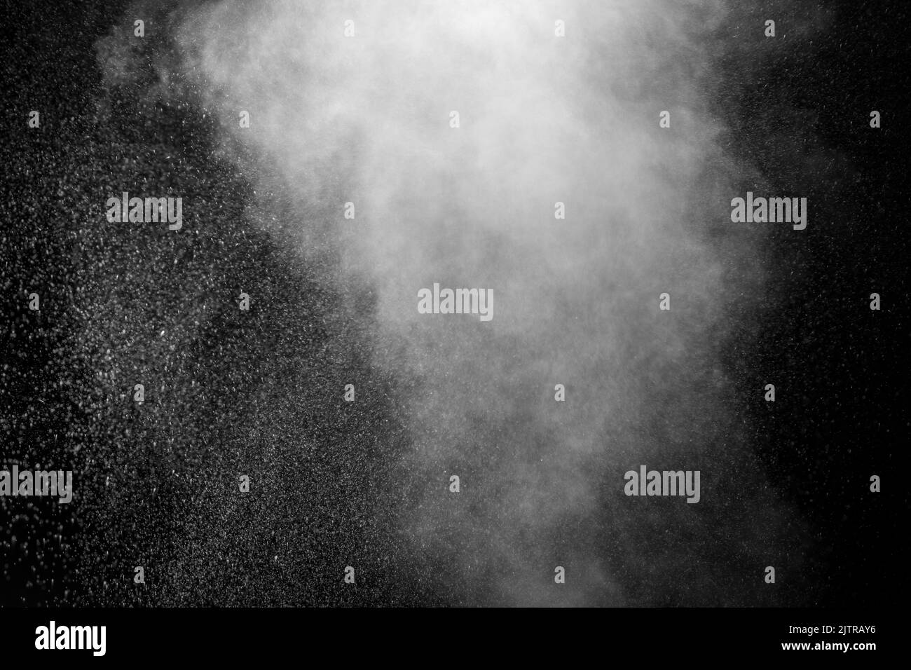 Vapeur blanche bouclés qui s'élève et projection d'eau dans différentes directions isolée sur un fond noir à superposer. Évaporation du liquide an Banque D'Images