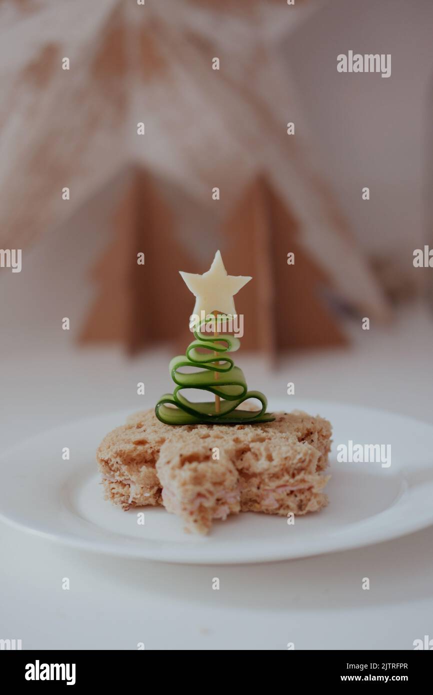 Concombre en forme d'arbre de Noël sur un bâton de cocktail poussé dans un sandwich avec une étoile de fromage. Banque D'Images