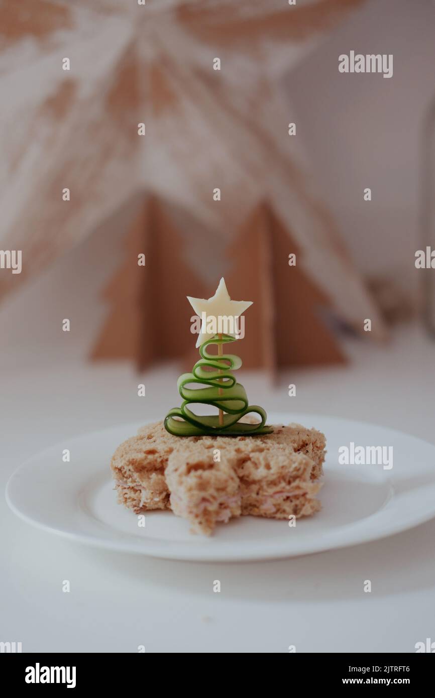 Concombre en forme d'arbre de Noël sur un bâton de cocktail poussé dans un sandwich avec une étoile de fromage. Banque D'Images