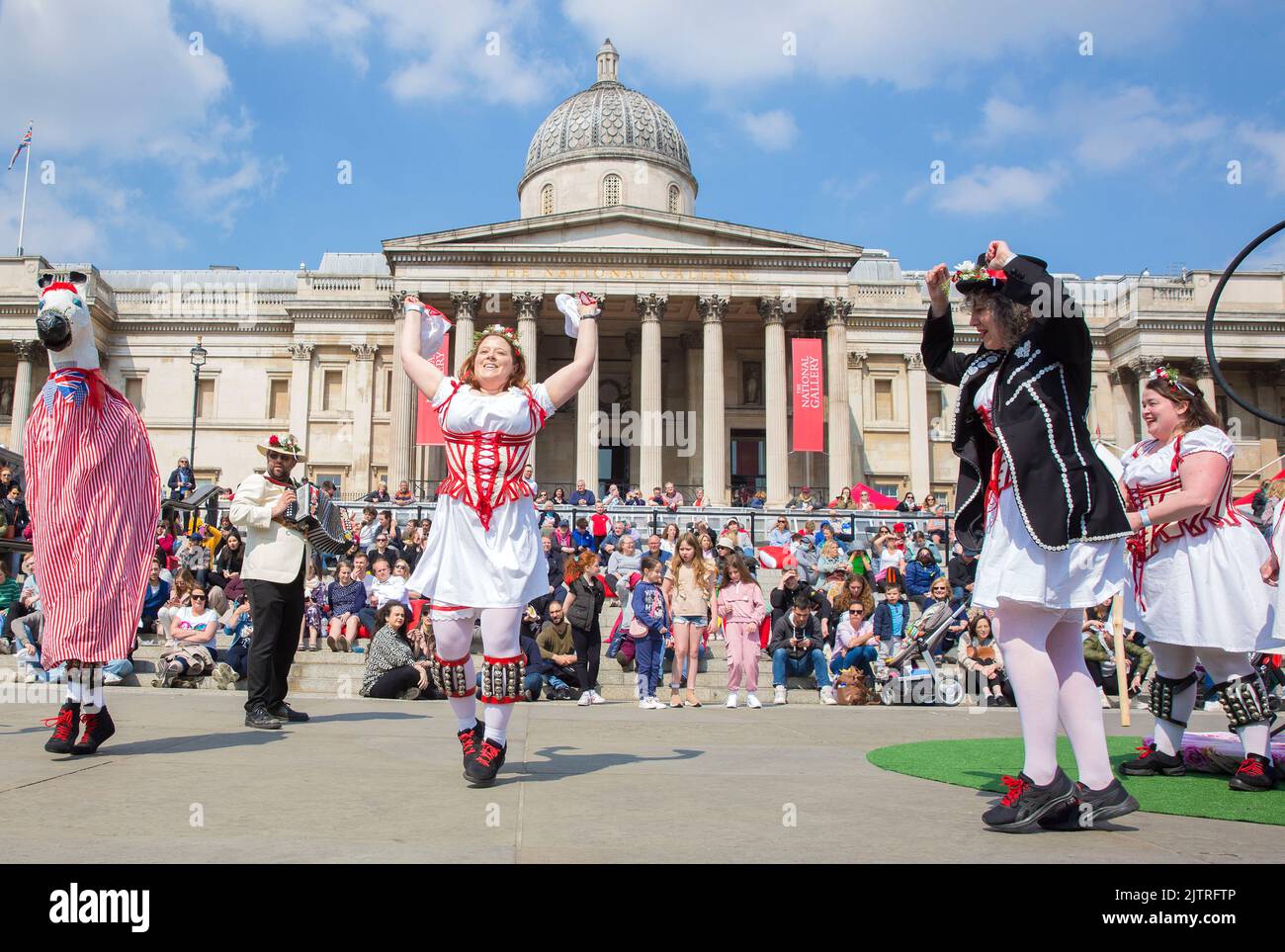 Les gens regardent les danseuses de Morris pendant qu'ils se rassemblent pour les célébrations de la fête de St George à Trafalgar Square, dans le centre de Londres. Banque D'Images