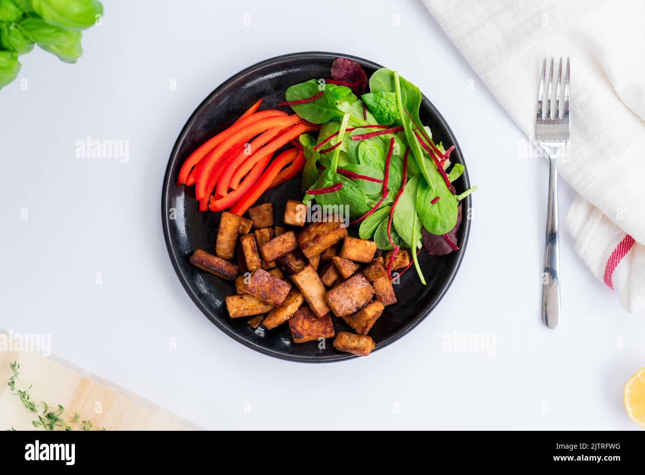 Vue de dessus salade verte saine, poivron en tranches et portion de tempeh rôti, faite de soja fermenté sur l'assiette. Protéines à base de plantes. Santé c Banque D'Images Vue de dessus salade verte saine, poivron en tranches et portion de tempeh rôti, faite de soja fermenté sur l'assiette. Protéines à base de plantes. Santé c Banque D'Images