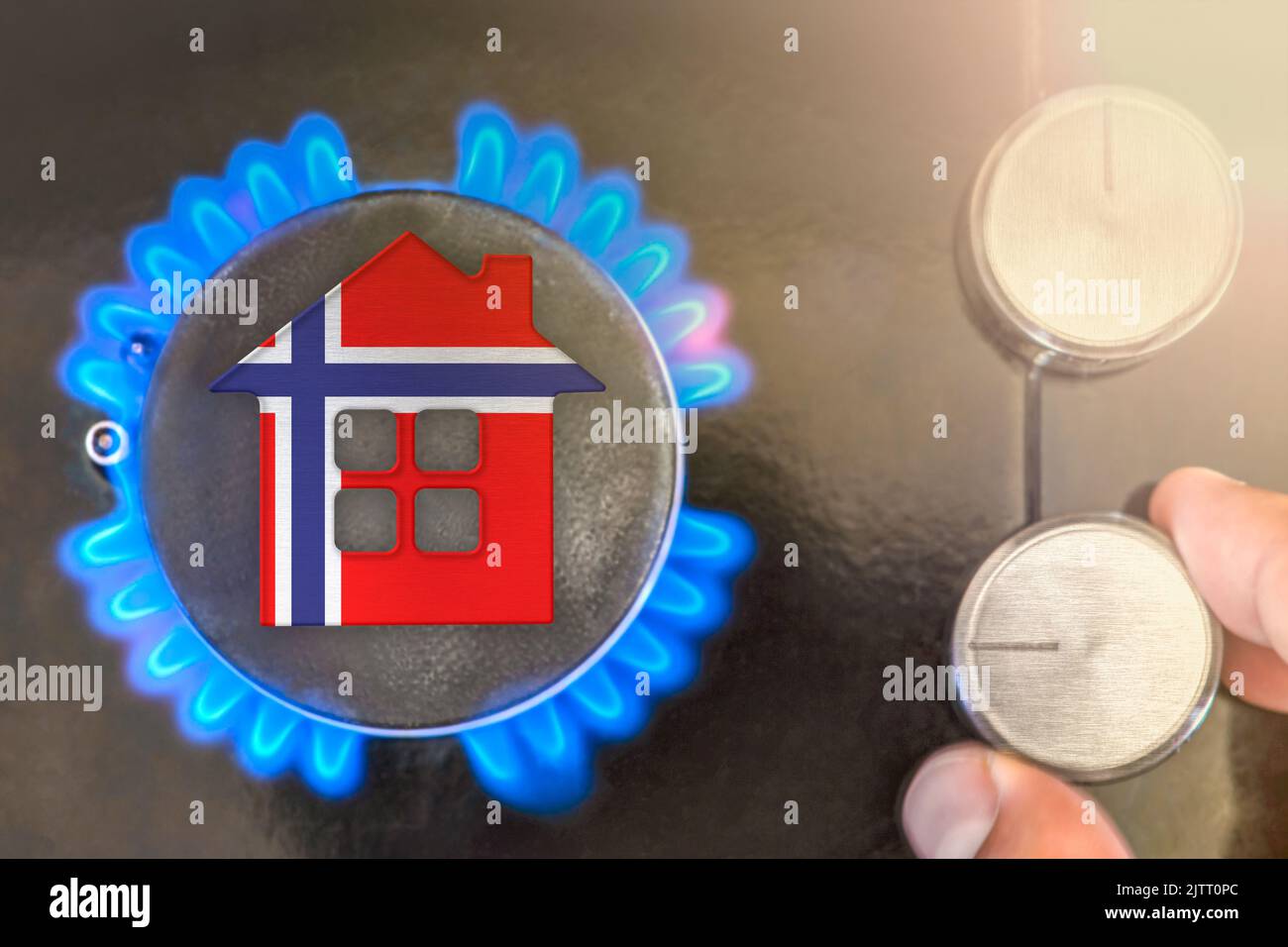 Saison de chauffage ou utilisation de gaz en Norvège. Concept, modèle d'une maison se tient près de la flamme d'une chaudière à gaz sur fond noir. Le coût de l'utilisation de naturel Banque D'Images