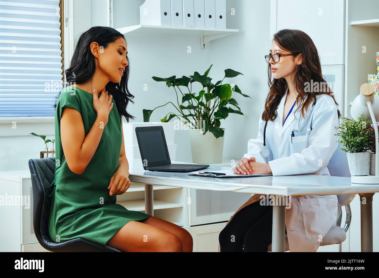 malade femme expliquant la maladie à une femme médecin à la clinique de consultation pendant le contrôle de santé Banque D'Images