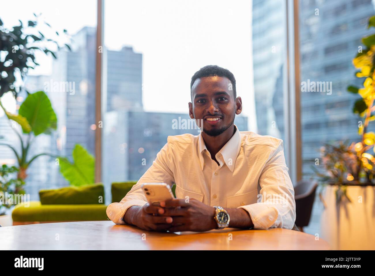 Portrait d'un jeune beau et élégant homme noir appréciant la vie en ville Banque D'Images