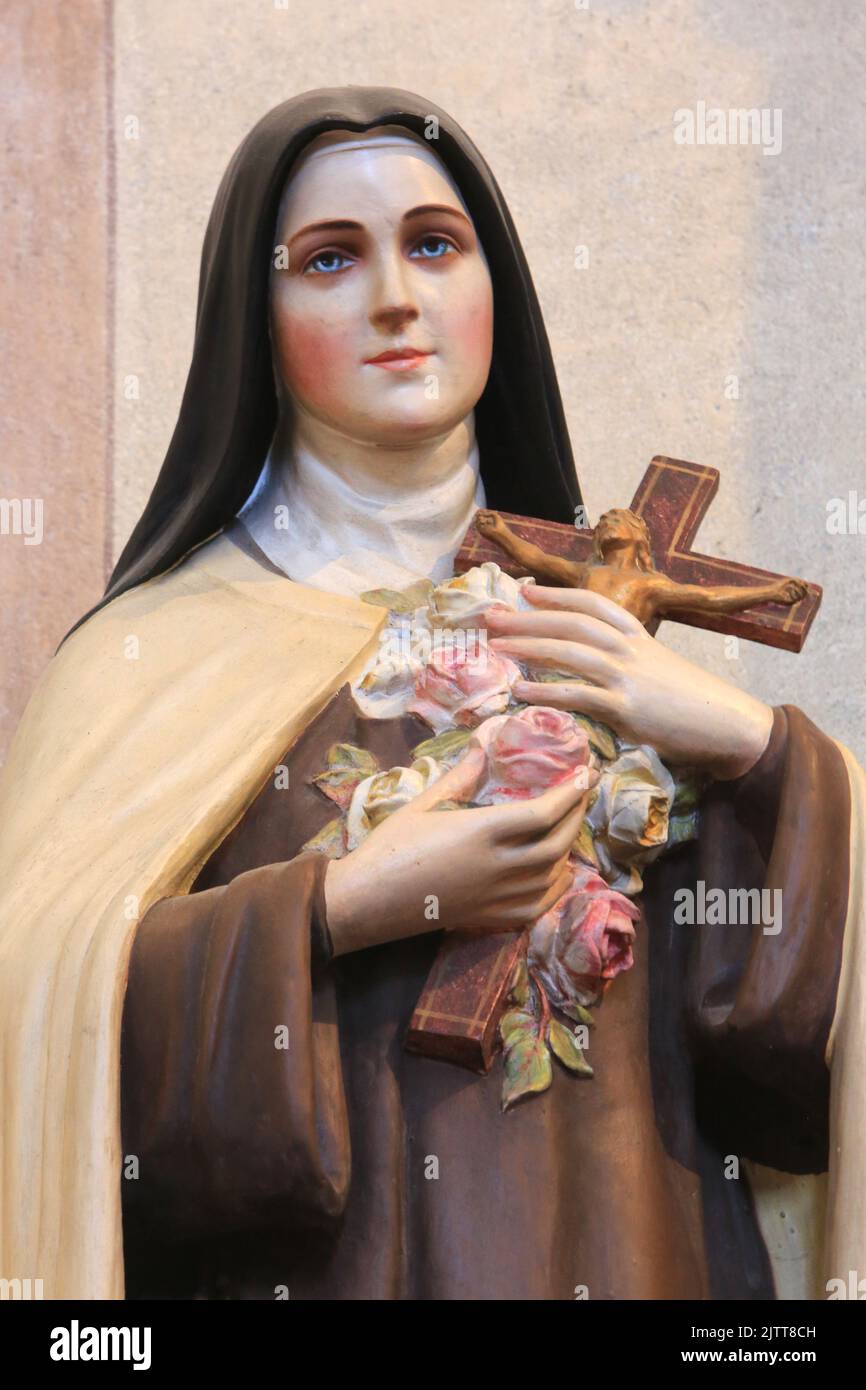 Marie-Bernadette Soubirous tenant un crucifix et des roses. Statue. Collégiale Saint-Jacques-le-majeur. Sallanches. Haute-Savoie. Auvergne-Rhône-Alpes Banque D'Images