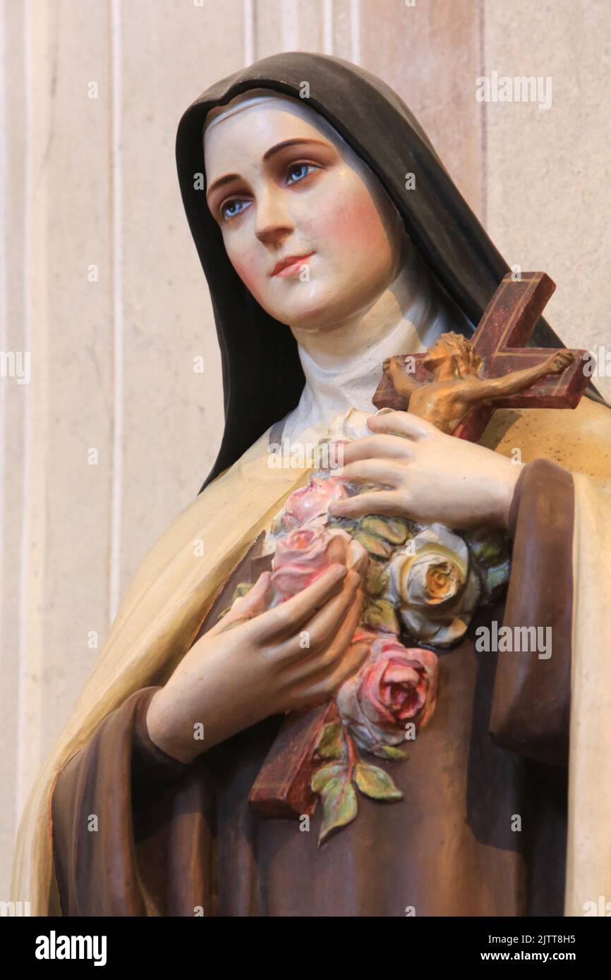 Marie-Bernadette Soubirous tenant un crucifix et des roses. Statue. Collégiale Saint-Jacques-le-majeur. Sallanches. Haute-Savoie. Auvergne-Rhône-Alpes Banque D'Images
