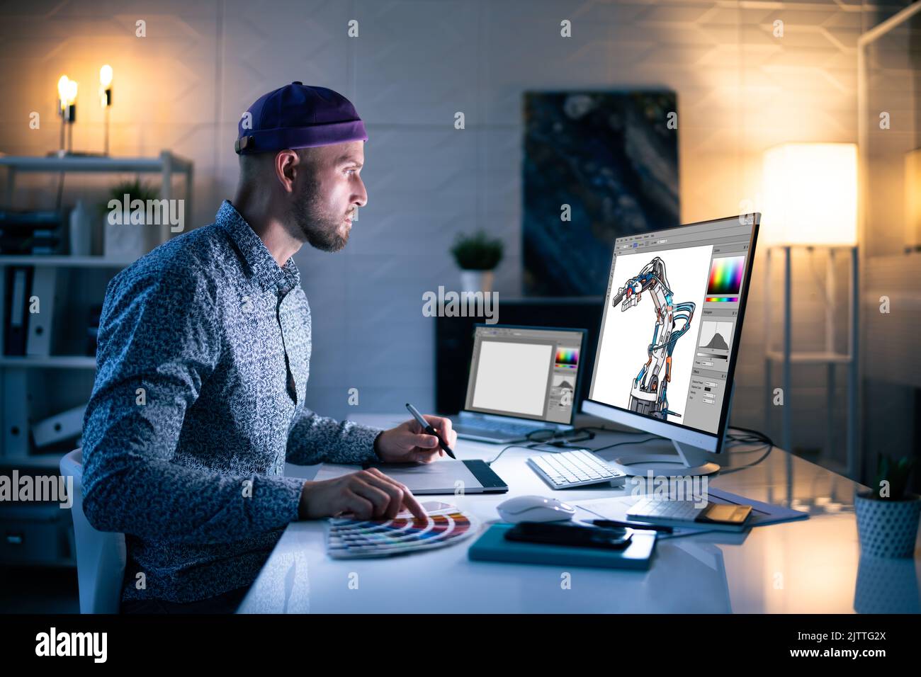Graphiste travaillant tard dans la nuit au bureau Banque D'Images
