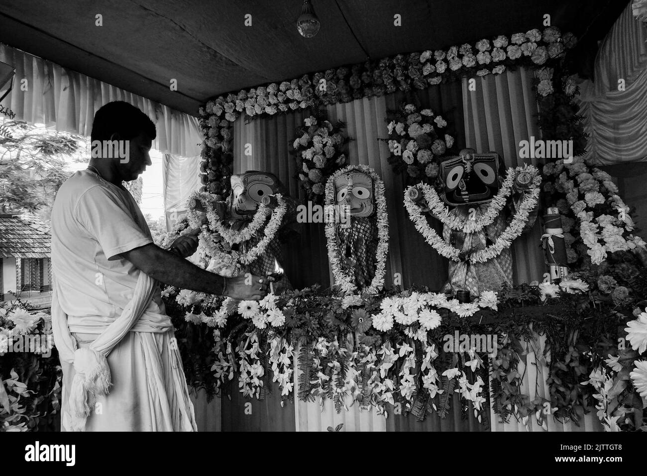 Howrah, Bengale-Occidental, Inde - 7th juillet 2019 : prêtre hindou adorant l'idole de Dieu Jagannath, Balaram et Suvodra à la lumière sainte. Festival Ratha jatra Banque D'Images