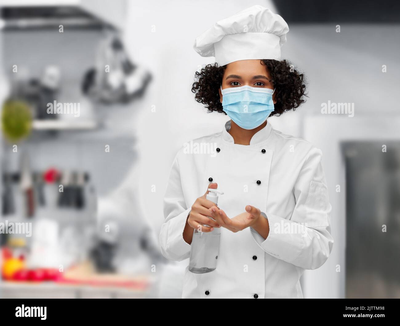 chef féminin en masque avec désinfectant pour les mains ou savon Banque D'Images