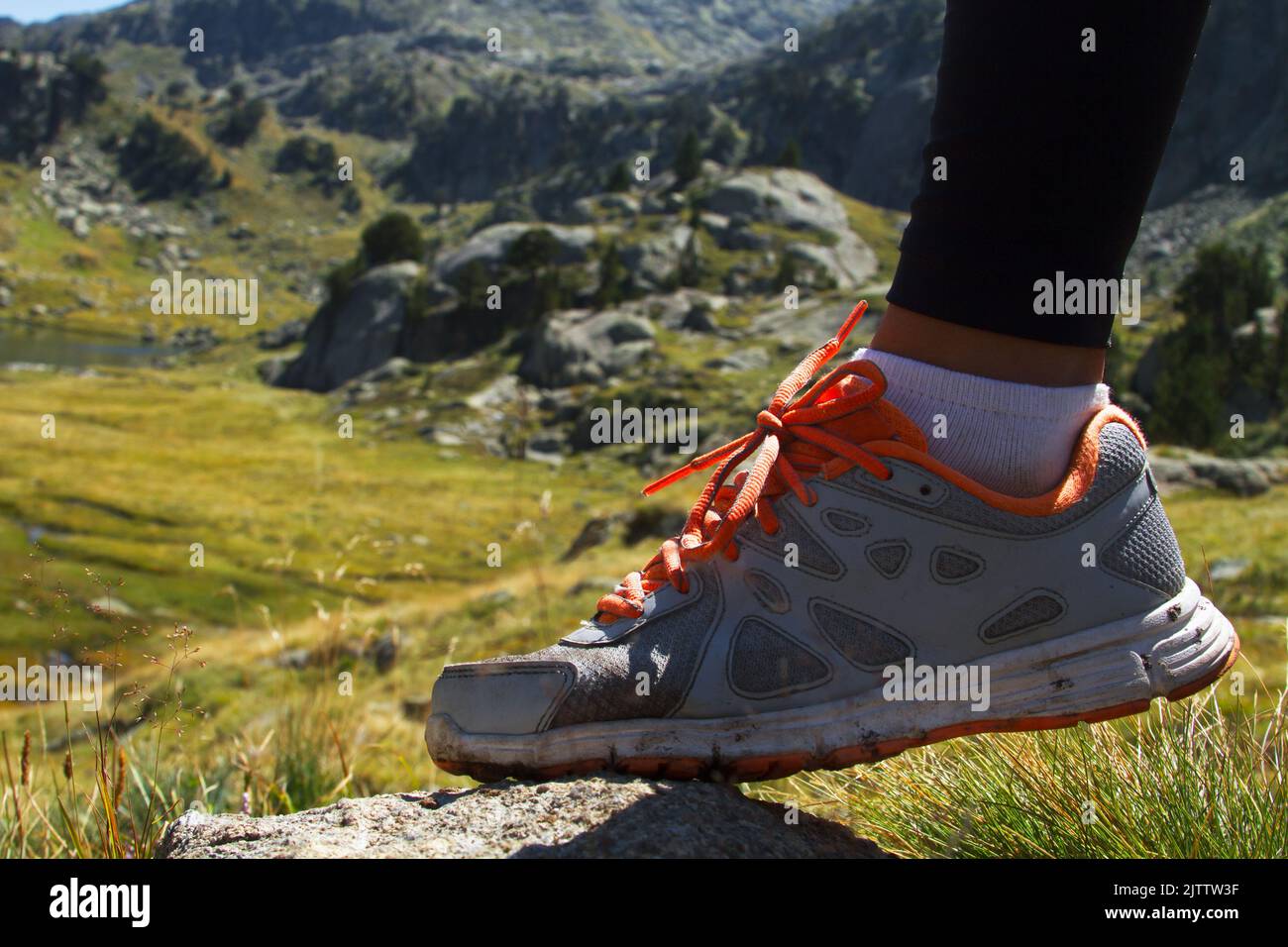 Pied femme avec baskets marchant sur la montagne Banque D'Images