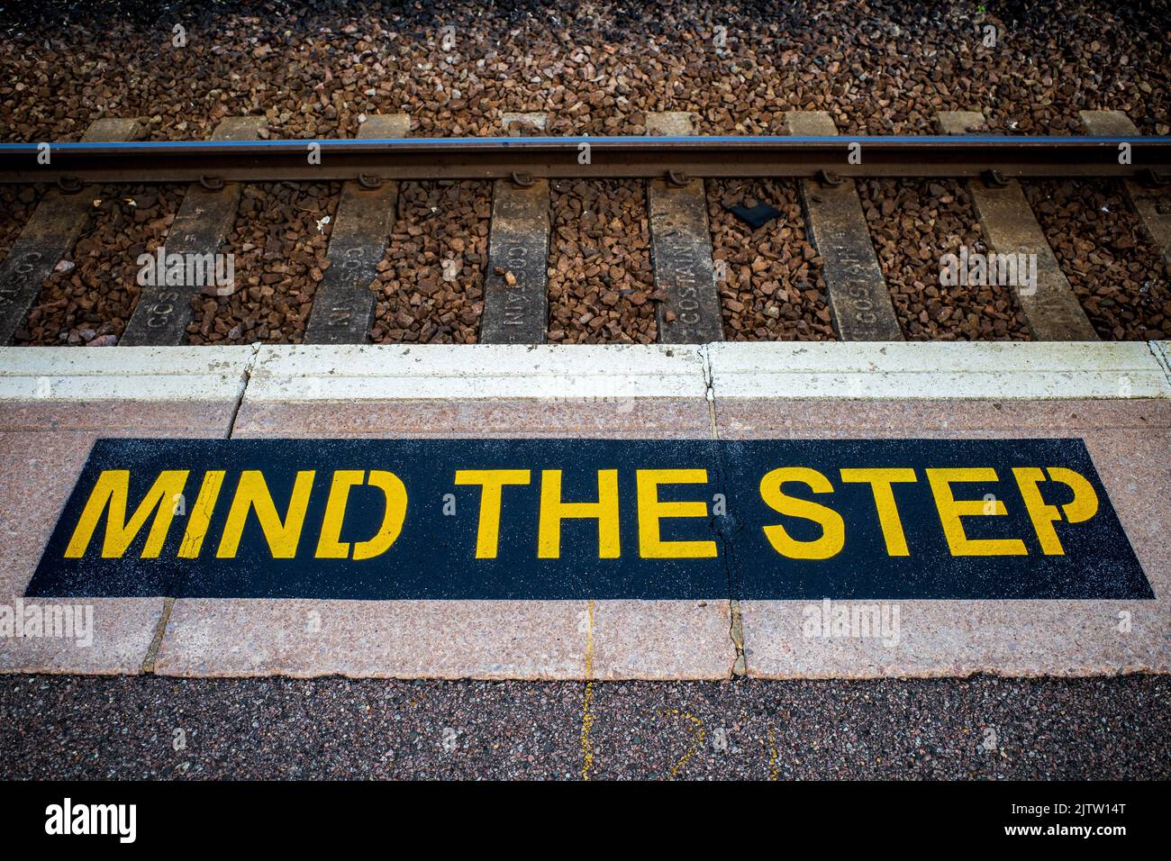 Attention au panneau Step sur une plate-forme de la gare ferroviaire britannique. Étiquette de sécurité de la plate-forme de la gare. Banque D'Images