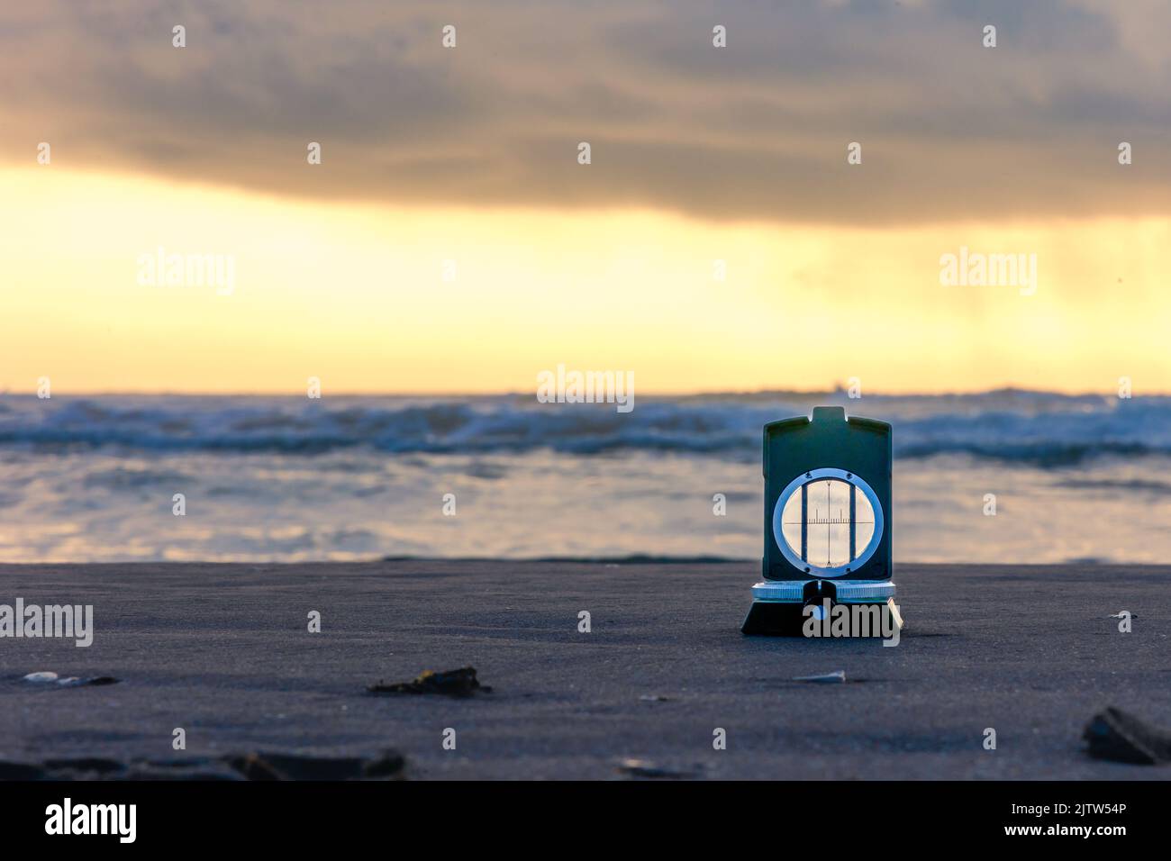 Lever du soleil sur la plage avec une boussole au premier plan Banque D'Images