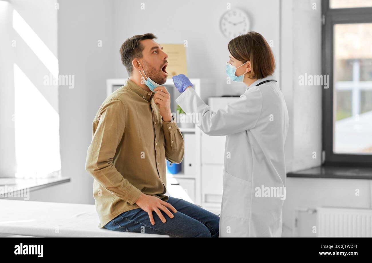 médecin vérifiant la gorge du patient mâle à l'hôpital Banque D'Images