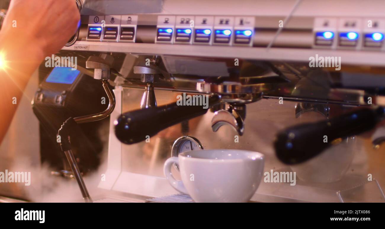Image de taches de lumière sur l'homme caucasien préparant le café dans le café Banque D'Images