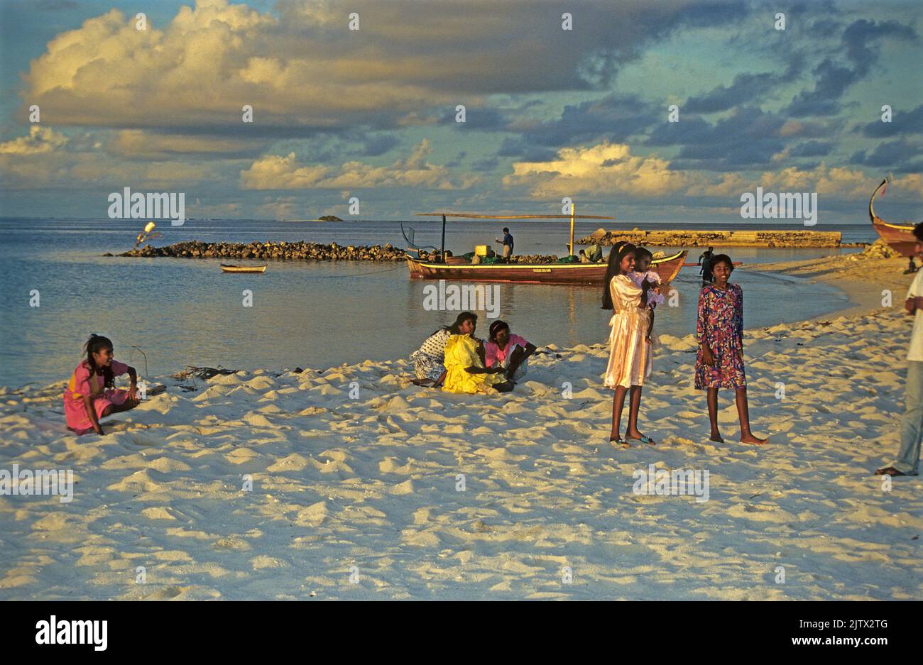 Jeunes filles à la plage, coucher de soleil, île d'accueil Mahembadhoo, Maldives, océan Indien, Asie Banque D'Images