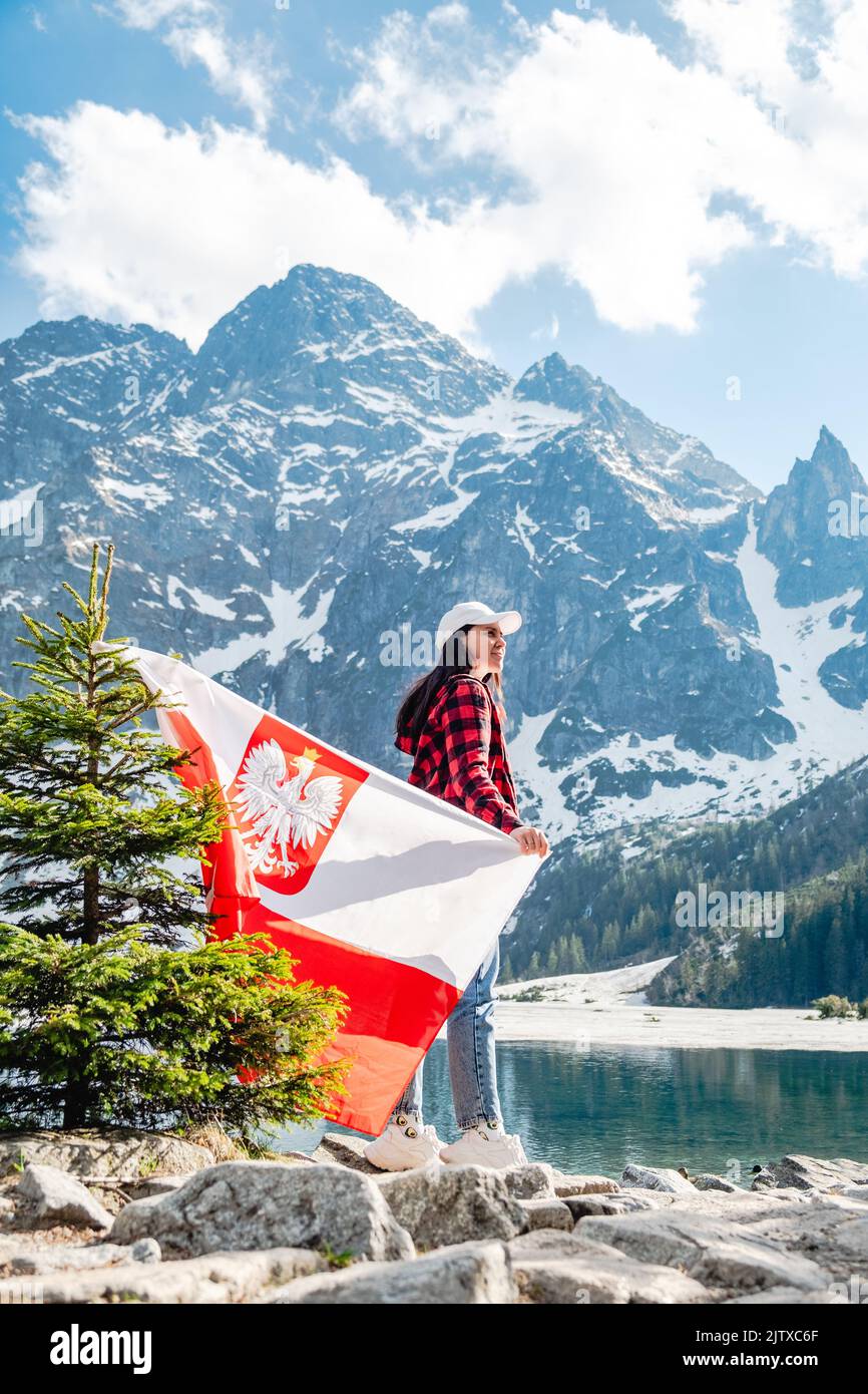 Une femme avec le drapeau de la Pologne est debout sur la rive d'un lac. Morskie Oko Banque D'Images