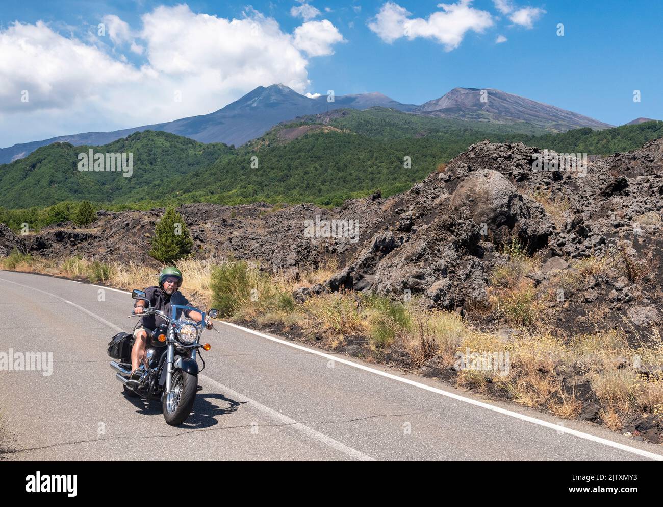 Motocycliste descendant la route raide de Mareneve sur l'Etna, Sicile, Italie. La route relie la station de ski de Piano Provenzana à la côte Banque D'Images